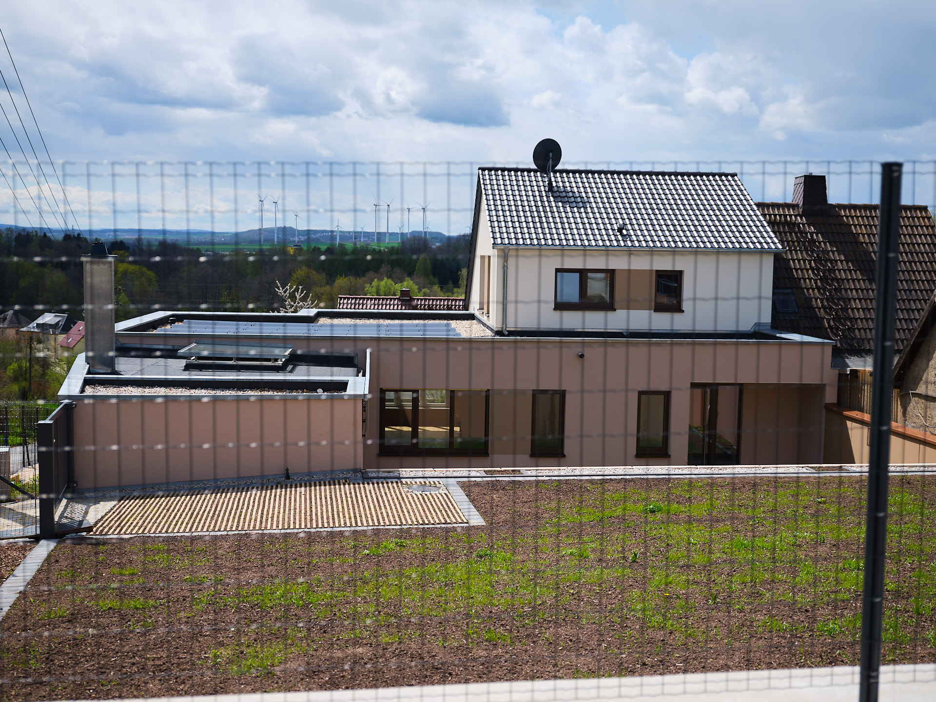 Massiv gebaute Doppelhaushälfte in der Region Chemnitz mit Photovoltaikanlage, flachem Anbau und moderner Fassadengestaltung.
